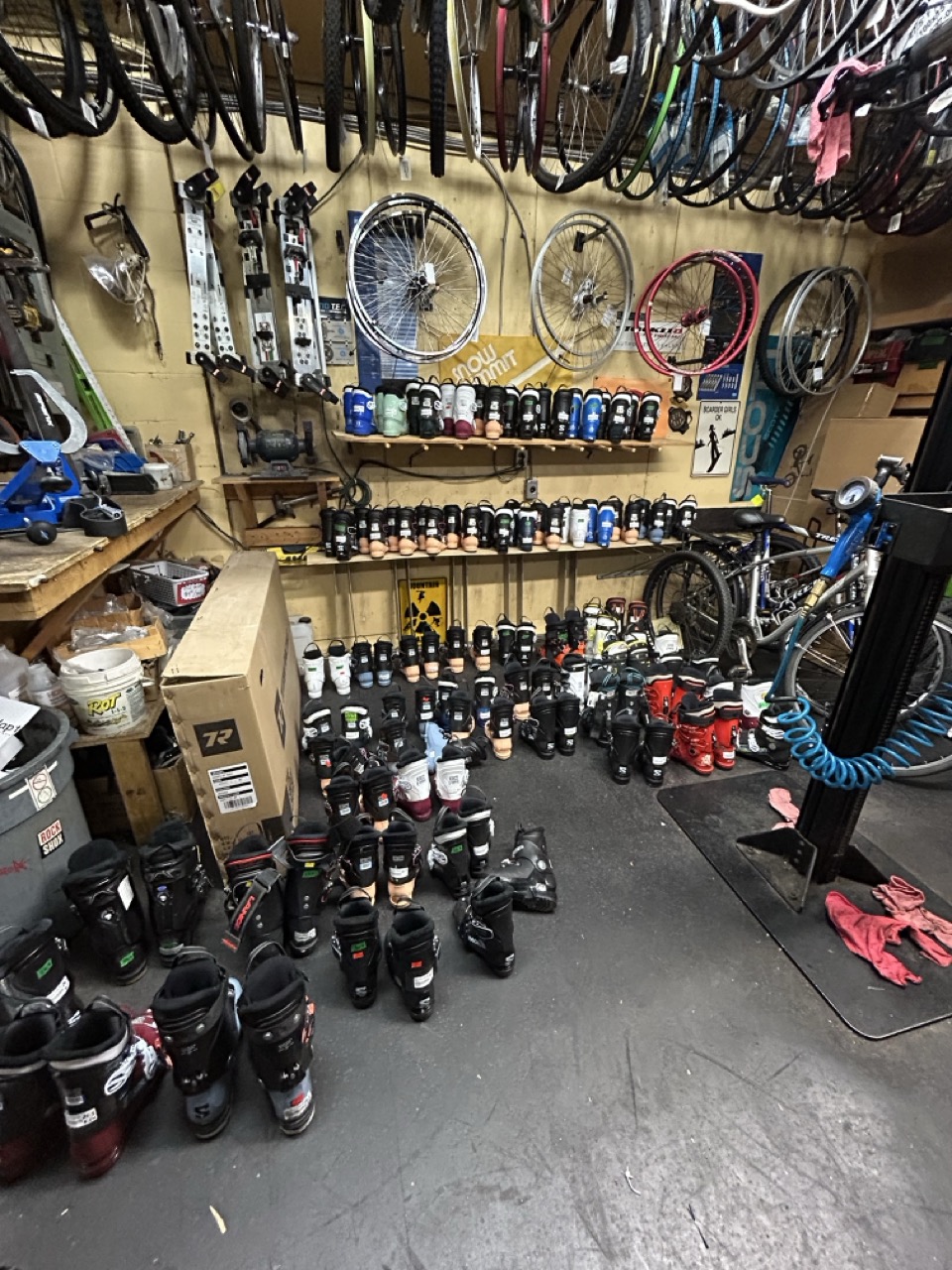 Ski boots stacked all over the bike repair area at North Shore Sports Swap